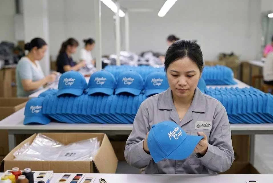 MasterCap quality control inspector examining bulk custom caps on the factory production line for a B2B order