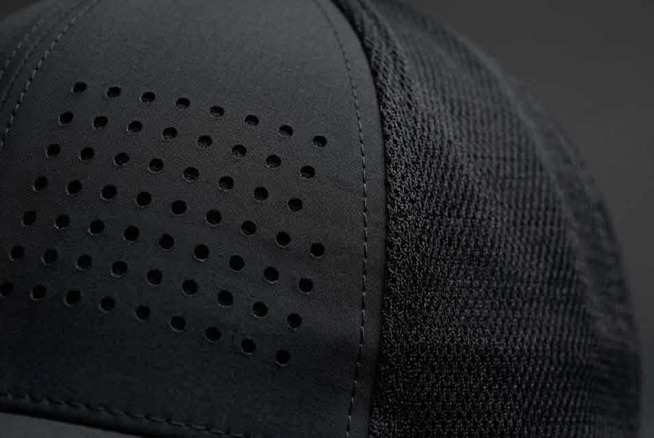 Macro detail of laser-cut ventilation holes and high-density soft mesh on a premium custom sports cap