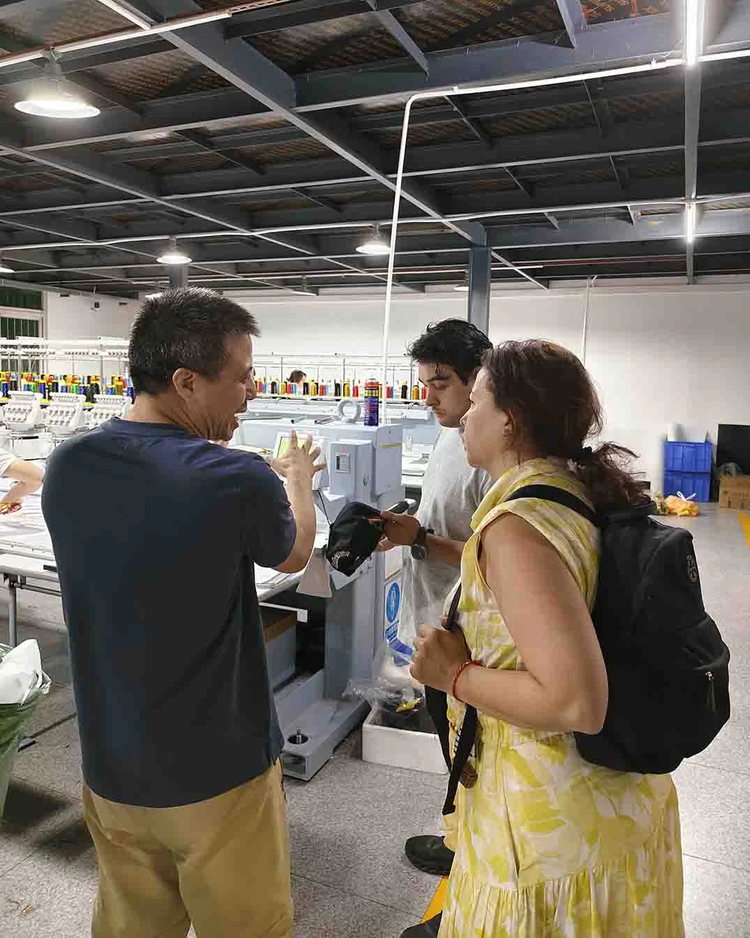 Boss Henry explaining the Barudan embroidery machine process to Mexican clients