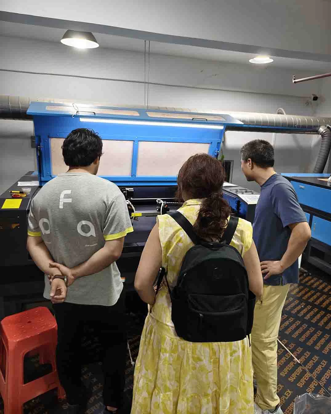 Clients inspecting the laser perforation machine at MasterCap factory