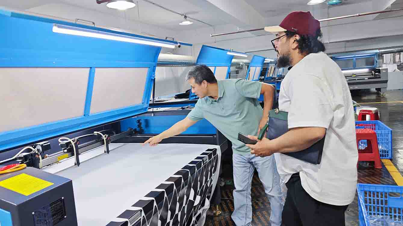 MasterCap team demonstrating advanced laser cutting and perforation technology for custom hats