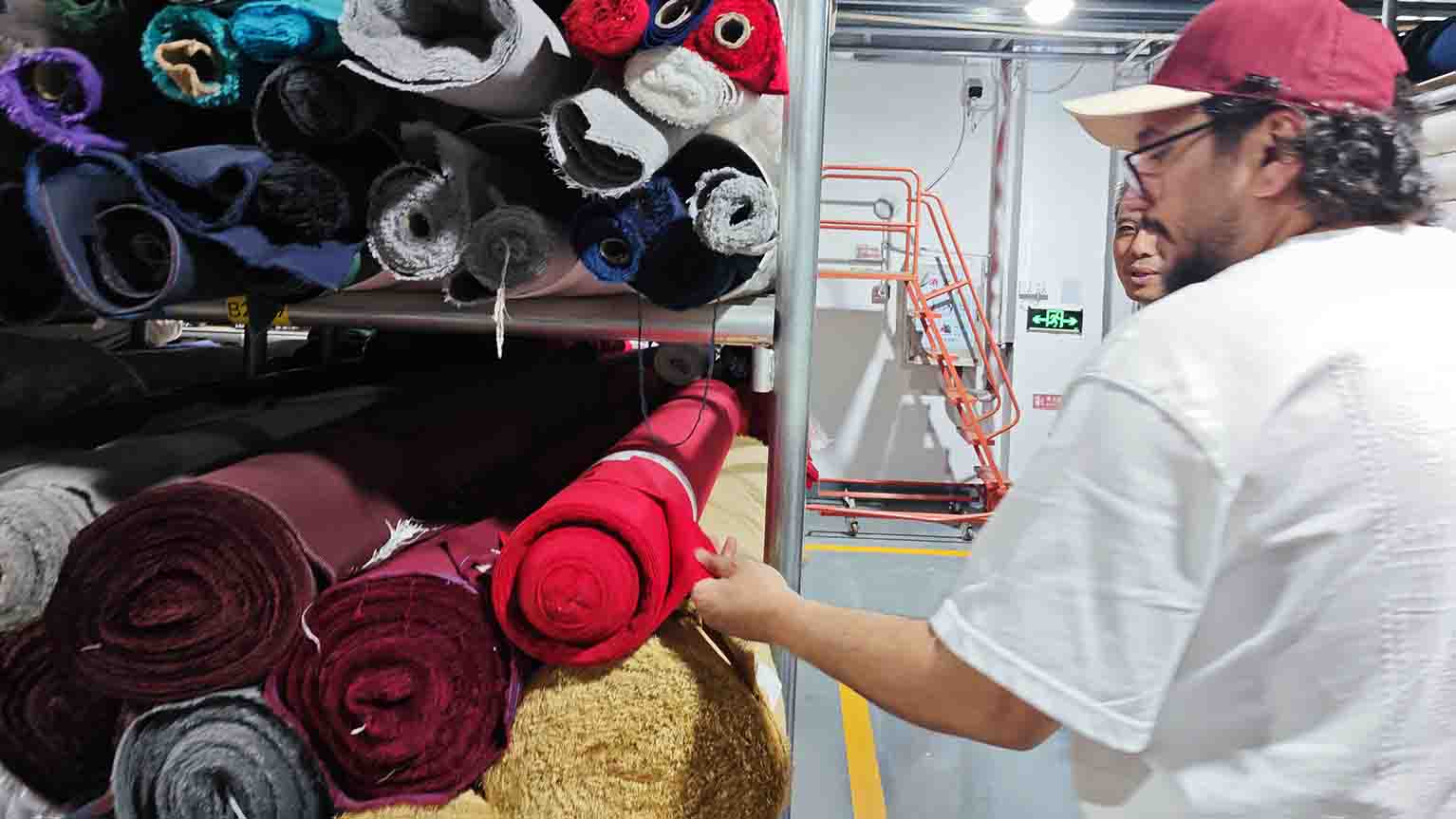 Client selecting premium fabrics like suede and wool in MasterCap's material warehouse